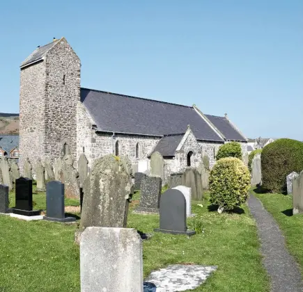  ??  ?? St Mary’s church, with its gabled tower, was built in an elevated location to protect it from coastal storms and sand erosion (left). The south porch entrance has a slightly lopsided appearance due to missing archway stonework (below). Sailors Corner: a memorial to shipwreck victims (bottom).