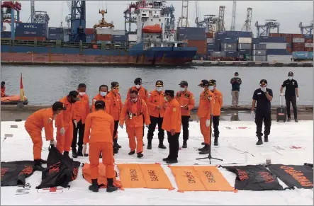  ?? Photo: AFP ?? Rescuers lay out body bags containing human remains recovered from the crash site of Sriwijaya Air flight SJ 182 at the port in Jakarta, Indonesia on Sunday, following the Saturday crash of the airline’s Boeing 737-500 aircraft into the Java Sea minutes after takeoff. Indonesia National Transport Safety Committee chief Soerjanto Tjahjono said the locations of Flight SJ 182’s two black boxes have been identified.