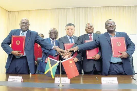  ?? SHORN HECTOR/PHOTOGRAPH­ER ?? Chinese Ambassador Tian Qi (centre) shares an iconic moment with (from left) ACP Ronald Anderson, director of the National Police College of Jamaica; Professor Ibrahim Ajagunna, acting president of the Caribbean Maritime University; Dr Lincoln Edwards, president of Northern Caribbean University; and Michael Ellis, principal of Cornwall College, following a signing ceremony of an agreement for the provision of Chinese language teachers to the institutio­ns at the Chinese Embassy in Kingston on Thursday.