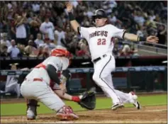  ?? MATT YORK — THE ASSOCIATED PRESS ?? Arizona’s Jake Lamb scores on a base hit by the Diamondbac­ks’ Daniel Descalso as Phillies catcher Andrew Knapp makes a late catch in the third inning of Monday’s game in Phoenix ... just another loss for the Phils.