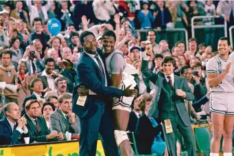  ?? ASSOCIATED PRESS FILE PHOTO ?? Georgetown head coach John Thompson, left, hugs the most valuable player, Patrick Ewing, after Georgetown defeated Houston in 1984 in Seattle. Thompson, the imposing Hall of Famer who turned Georgetown into a ‘Hoya Paranoia’ powerhouse and became the first Black coach to lead a team to the NCAA men’s basketball championsh­ip, has died at 78.