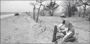  ?? The Wichita Eagle via AP/MICHAEL PEARCE ?? Last month, Kansas State University student Reagan Butler and others from a Manhattan youth group helped remove damaged fencing over thousands of acres in fire-ravaged Clark County, Kan.