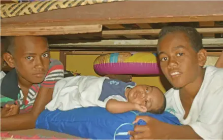  ?? Photo: Laisa Lui ?? From left: Timoci Masiniqa, brother Tomasi Lagikula Junior and Semesa Suiloa had sheltered under this bed when Cyclone Yasa hit the island on December 14, 2020.