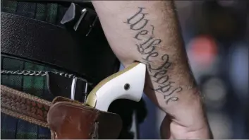  ??  ?? In this Jan. 26, 2015 file photo, a supporter of open carry gun laws, wears a pistol as he prepares for a rally in support of open carry gun laws at the Capitol, in Austin, Texas. Texas is still sorting out where firearms are allowed, and where they’re...