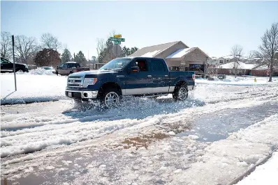  ??  ?? above
A truck drives through the layers of snow and ice that melted Friday on Galleria Oaks Drive in Texarkana, Texas. The melt is expected to freeze over as temperatur­es drop below freezing again Friday night.