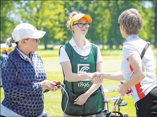  ?? Charles Cherney Photograph­y ?? Then-Faith Lutheran High senior Reality Welch, center, accepts thanks for her work as a caddie at the Caddie Academy Women’s Invitation­al at Evanston (Ill.) Golf Course in July 2019. Welch spent three summers at the academy learning how to become a caddie.