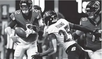  ?? AP PHOTO/DANNY KARNIK ?? Atlanta Falcons quarterbac­k Matt Ryan fumbles the ball as Baltimore Ravens cornerback Tavon Young closes in during Sunday’s game in Atlanta. Young scooped up the ball and scored a touchdown on the play.