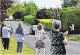  ??  ?? Warm welcome: Neighbours and friends clap Dónal Lawlor as he makes his way home