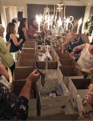  ?? MIA WALSH VIA AP ?? This September 2018 photo provided by Mia Walsh shows moms making care packages for their children away at college at the Baltimore, Md., home of Mia Walsh. Care package parties are a great way for parents to bond as they swap updates about their children, support each other and pack a fun box of treats for their child away at school.
