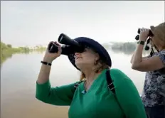 ?? Pam Panchak/Post-Gazette ?? Sue Arnold, of Washington’s Landing, and Linda Hand, of Mt. Lebanon, scan the shoreline for birds during the National Aviary Riverboat Birding Tour on Rivers of Steel’s RiverQuest Explorer on Saturday.