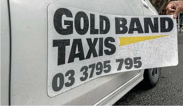  ?? STACY SQUIRES/ STUFF ?? Gold Band Taxis general manager Graham Moore says magnetic signs are much cheaper than painted logos. However, they also make it easy for drivers to work for rival operators such as Uber, something his company has banned.