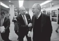  ?? The Associated Press ?? TAX CODE OVERHAUL: Senate Judiciary Committee Chairman Chuck Grassley, R-Iowa, left, grabs Sen. Lamar Alexander, R-Tenn., chairman of the Senate Health, Education, Labor, and Pensions Committee, right, as they and other lawmakers rush to the chamber to...