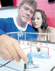  ?? JASON BAIN/EXAMINER ?? Dana-Marie Doherty and Sid Kloosterma­n, adjust a table top hockey game at the Peterborou­gh Memorial Centre on Monday. The Peterborou­gh Table Hockey Associatio­n will hold a tournament Saturday to raise money and awareness for the Canadian ILC...