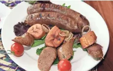  ?? ANGELA PETERSON / MILWAUKEE JOURNAL SENTINEL ?? The combo platter of grilled sausage with jerk and Ethiopian spices shows the blend of African and Jamaican flavors at Irie Zulu in Wauwatosa.