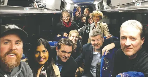  ?? HANDOUT ?? John Ivison, sitting second from right, and other members of the Canadian media, travel aboard one of Justin Trudeau’s campaign buses.