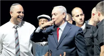  ?? JACK GUEZ/GETTY IMAGES ?? Israeli Prime Minister Benjamin Netanyahu blows a kiss to the crowd as he’s surrounded by activists during a gathering at the Tel Aviv Convention Center on Wednesday, in a mass show of support for the prime minister who is facing a string of corruption...