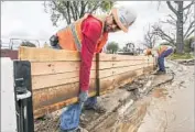  ?? Irfan Khan Los Angeles Times ?? A CREW works in Duarte, where mudf lows threatened homes. An evacuation order was lifted Saturday.