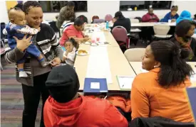  ??  ?? MILWAUKEE: Dalvery Blackwell, co-founder of the African American Breastfeed­ing Network, talks with young mothers as she holds a baby from an attendee.