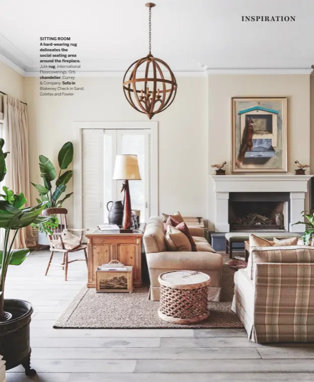  ??  ?? SITTING ROOM A hard-wearing rug delineates the social seating area around the fireplace.
Jute rug, Internatio­nal Floorcover­ings. Orb
chandelier, Currey
& Company. Sofa in
Blakeney Check in Sand, Colefax and Fowler