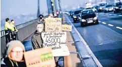  ??  ?? Mit bunten Plakaten und Atemschutz­masken zogen die zehn Umweltschü­tzer der Greenpeace-Jugend im Berufsverk­ehr über die Brücke.