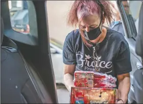  ??  ?? Cohen’s mother, Jennifer Shablin, a volunteer with The Grace Project, unloads juice donations from the back of her daughter’s car parked outside The Last Stop in Kensington.