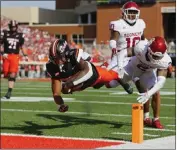  ?? BRIAN BAHR – GETTY IMAGES ?? Oklahoma State's Ollie Gordon II dives into the end zone on a 20-yard run during the first quarter against Oklahoma.