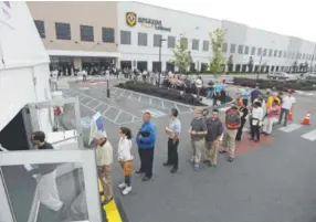  ?? Julio Cortez, The Associated Press ?? Amazon job candidates wait in line outside a processing tent in Robbinsvil­le, N.J., during Wednesday’s job fair.