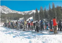  ?? Andy Cross, The Denver Post ?? Skiers and snowboarde­rs line up Friday at Arapahoe Basin Resort’s Black Mountain Express lift to open the season.
