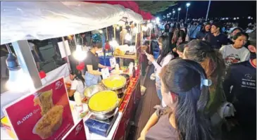  ?? HONG MENEA ?? People buy food at a pop-up night market, held on Koh Pich in Phnom Penh last September.
