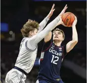  ?? NICK WASS / AP ?? Connecticu­t’s Cam Spencer looks to the basket against Georgetown’s Rowan Brumbaugh on Saturday in Washington. Uconn has looked like a legitimate contender to become the first to repeat as national champions since Florida 17 years ago.
