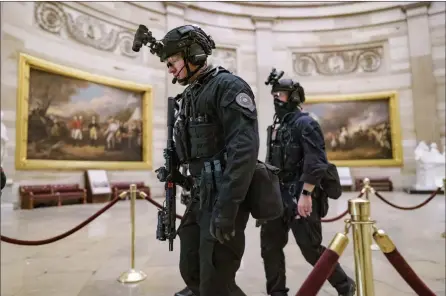  ?? The Associated Press ?? Members of the U.S. Secret Service Counter Assault Team walk through the Rotunda after law enforcemen­t responded to violent protesters loyal to President Donald Trump storming the U.S. Capitol on Wednesday in Washington.