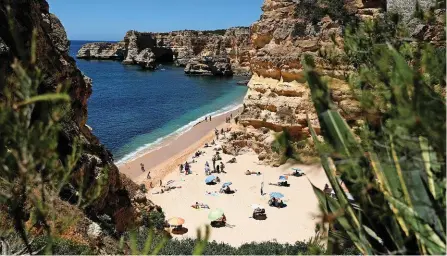  ?? REUTERS ?? Sommerferi­en in der Algarve (Bild: Strand von Marinha): In Portugal steigen zurzeit die Corona-Fallzahlen wieder an.