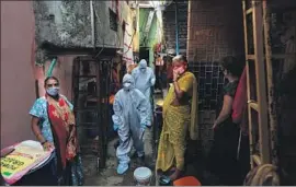  ?? Rafiq Maqbool Associated Press ?? IN DHARAVI, a densely populated labyrinth in the heart of Mumbai that was the setting for the film “Slumdog Millionair­e,” health workers walk among residents.