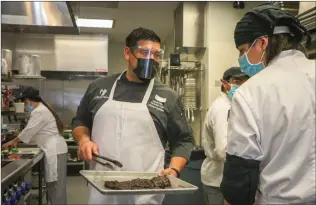  ?? Courtesy photo ?? (Above) Chef Daniel Otto teaches a culinary arts student how to properly sear a steak. (Right) Dr. Hencelyn Chu, right, films a lab lecture on how to operate a blood count analyzer for her medical lab technician students.