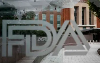  ?? AP Photo/Jacquelyn Martin ?? This 2018 file photo shows the U.S. Food and Drug Administra­tion building behind FDA logos at a bus stop on the agency’s campus in Silver Spring, Md.