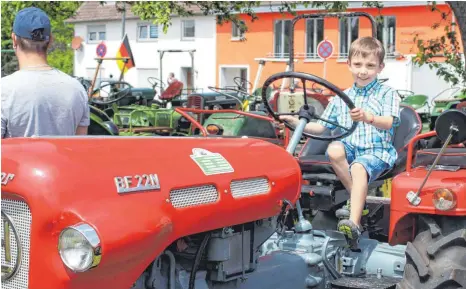  ?? FOTOS: GIWITSCH ?? Der fünfjährig­e Luca aus Ebersbach-Musbach strahlt übers ganze Gesicht, als er selbst auf dem Traktor sitzen darf.