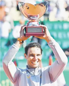  ??  ?? Rafael Nadal holds up the trophy as he celebrates his win over Kei Nishikori in their final match at the Monte-Carlo ATP Masters Series tournament in Monaco. — AFP photo