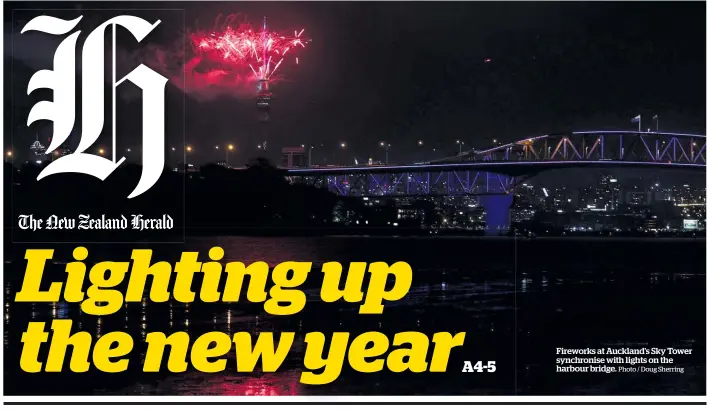  ?? Photo / Doug Sherring ?? Fireworks at Auckland's Sky Tower synchronis­e with lights on the harbour bridge.