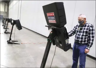  ?? The Sentinel-Record/Richard Rasmussen ?? GETTING READY: Garland County Election Commission Chairman Gene Haley sets up a voting machine at the Hot Springs Convention Center on Friday in preparatio­n for the start of early voting on Monday. The center is one of seven early voting locations for the 2020 general election and nonpartisa­n run-off election.