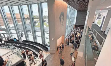  ?? PHOTOS BY MIKE LANG/HERALD-TRIBUNE ?? Guests mingle in the grand lobby of the new Booker Visual and Performing Arts Center before a ribbon-cutting Thursday for the new $28 million facility.