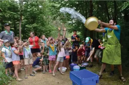  ?? FOTO MIA UYDENS ?? De leiding en kinderen van Kazou regio Mechelen-Turnhout amuseren zich met water in het kurkdroge domein in Lichtaart. “Zo kunnen we de bodem al wat bevochtige­n”, grappen ze.