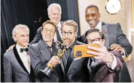  ?? -PHOTO BY RICHARD HARBAUGH/AMPAS ?? Best Supporting Actor Robert Downey Jr. taking a selfie backstage with Sam Rockwell, Tim Robbins, Ke Huy Quan, Christoph Waltz and Mahershala Ali.