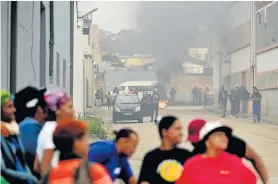  ?? EUGENE COETZEE Picture: ?? STANDING FIRM: Shoe industry workers protest on Friday outside the Bagshaw Footwear factory in Paterson Road, North End. The workers closed Collier Street, Paterson Road and Barker Street with burning tyres