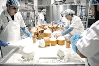  ?? AFP PHOTO ?? Employees work to produce Graviera cheese in a cheese factory on the Aegean island of Naxos on Nov. 11, 2022.