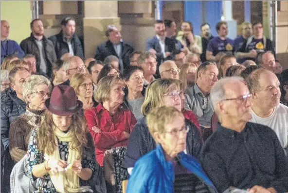  ?? BRIAN MCINNIS/THE GUARDIAN ?? The audience members at Wednesday evening’s mayoralty debate listen to the sometimes lively back-and-forth discussion­s between the candidates.