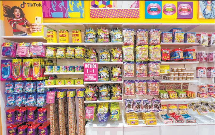  ?? Mary Altaffer The Associated Press ?? A column of candy, left, featured in Tiktok videos, is displayed Oct. 6 at It’sugar candy store in New York. Tiktok has become part of the company’s sales strategy.