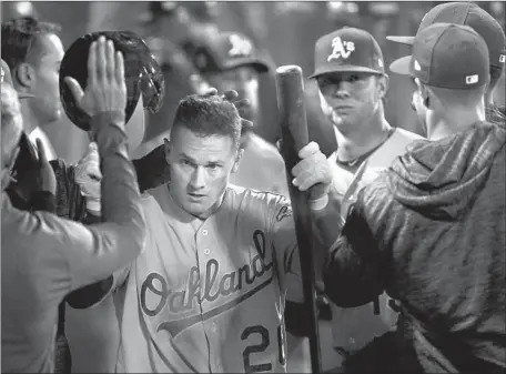  ?? Photograph­s by Kent Nishimura Los Angeles Times ?? OAKLAND THIRD BASEMAN Matt Chapman is the center of attention during the Athletics’ victory over the Angels on Saturday night. Chapman went one for three, a triple that left fielder Justin Upton lost in the lights in the eighth inning.