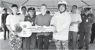  ?? — Gambar Bernama ?? KURANGKAN BEBAN: Dr Wee Ka Siong (depan dua, kanan) menyerahka­n replika kunci bangunan kepada Ketua Pasukan Bomba dan Penyelamat Sukarela (CRSM) Ayer Hitam Wong Boon Hang (depan, kiri) pada Majlis Perasmian Bangunan Pasukan Bomba dan Penyelamat...