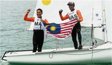 ??  ?? Sail away with us: Muhammad Uzair Amin Mohd Yusof (left) and Naquib Eiman Shahrin celebratin­g after winning the Internatio­nal 420 gold in Langkawi. — Bernama