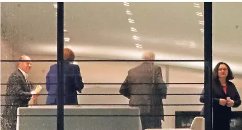  ?? FOTO. RTR ?? Durch ein Fenster im Kanzleramt waren gestern Abend Olaf Scholz, Angela Merkel, Horst Seehofer und Andrea Nahles (v.l.) zu sehen.